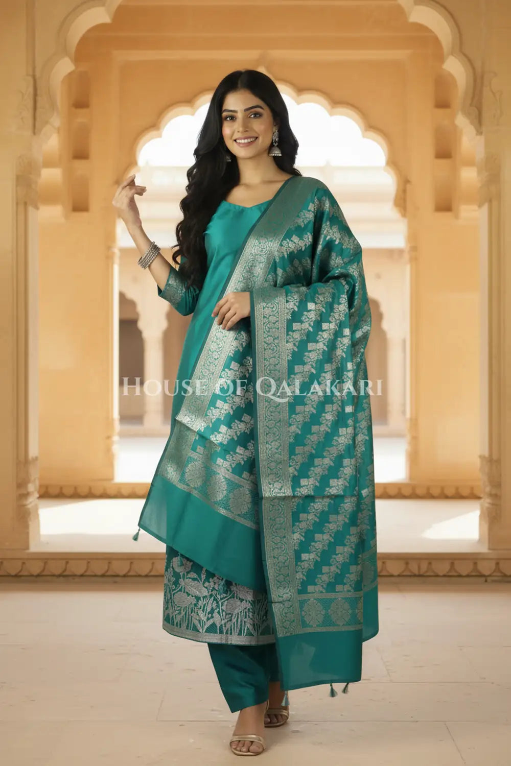 Banarasi silk Unstitched Dress Material in Emerald Green and with lotus floral border and diagonal striped zari work dupatta – festive pose
