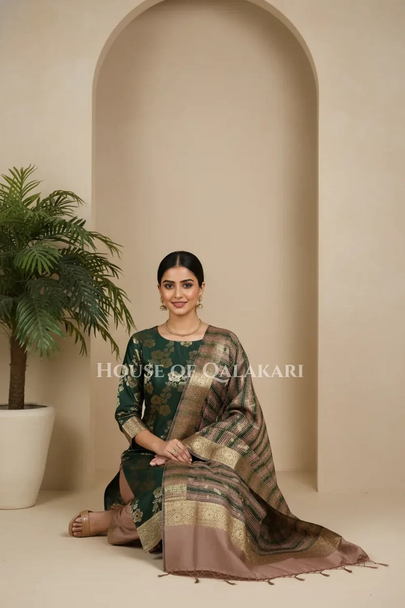 Banarasi Cotton Silk blend Unstitched Dress Material in deep emerald green and rose gold contrast with Intricate Zari Buti – sitting pose