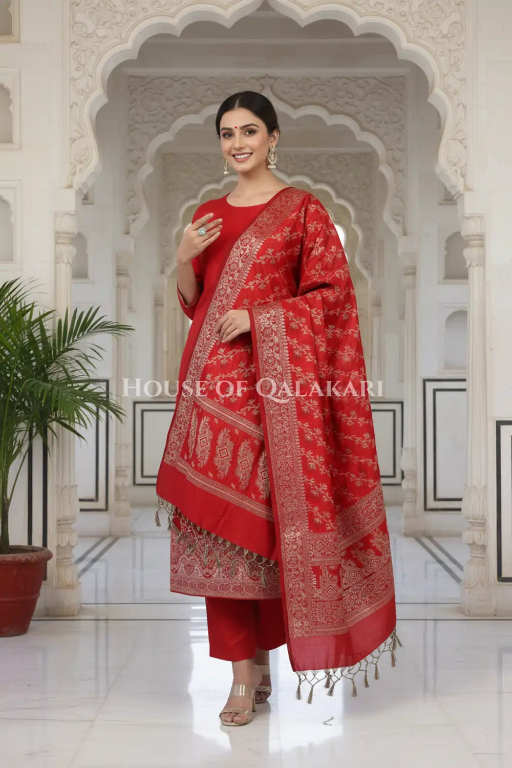 Banarasi Unstitched Dress Material in Red and with plain body and resham border and diagonally striped resham dupatta – festive pose