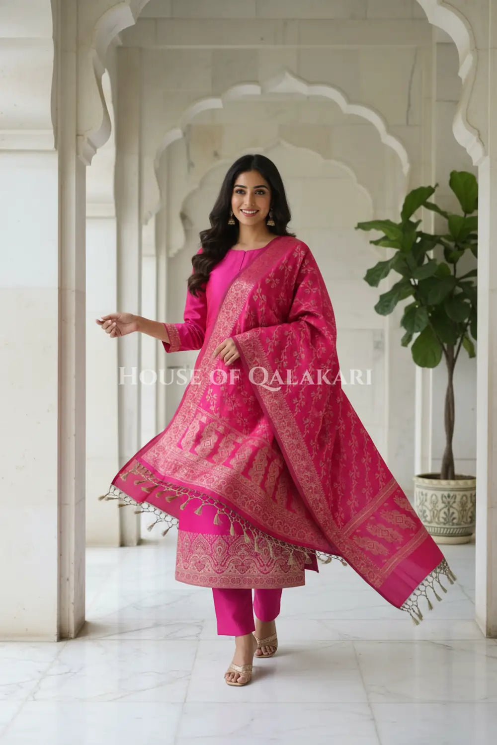 Banarasi Unstitched Dress Material in Rani Pink and with plain body and resham border and diagonally striped resham dupatta – festive pose