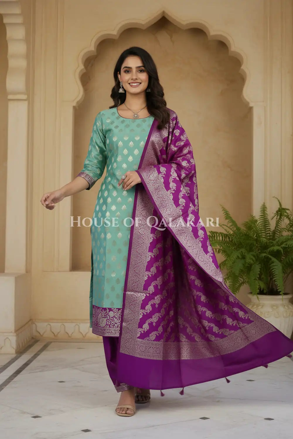 Banarasi Silk Unstitched Dress Material in Light Teal Green and Rich Purple contrast with Intricate Zari Buti – festive pose