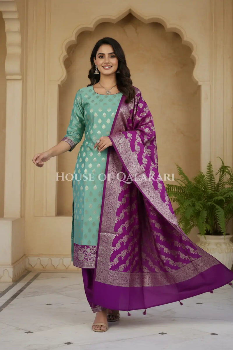 Banarasi Silk Unstitched Dress Material in Light Teal Green and Rich Purple contrast with Intricate Zari Buti – festive pose