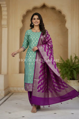 Banarasi Silk Unstitched Dress Material in Light Teal Green and Rich Purple contrast with Intricate Zari Buti – festive pose