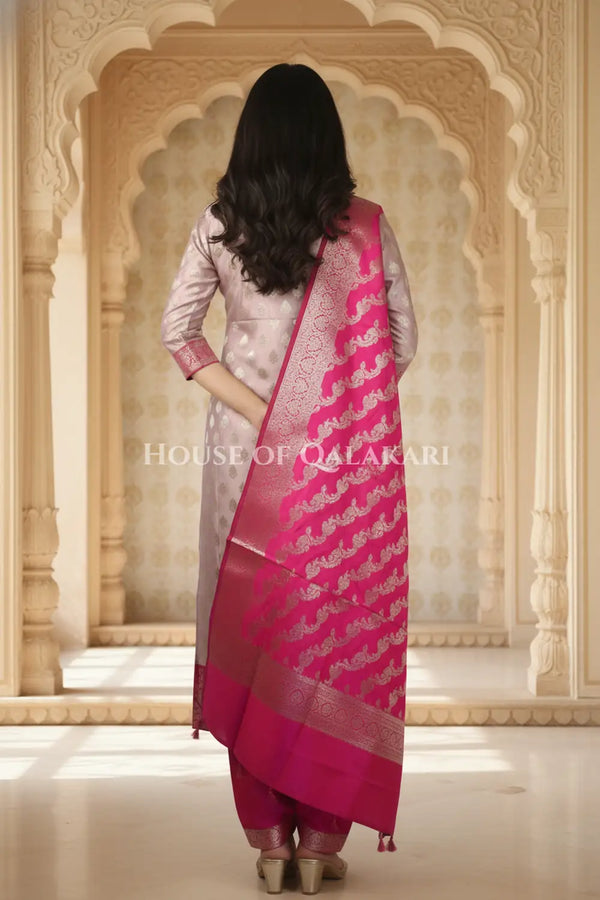 Banarasi Silk Unstitched Dress Material in Light Purple and rani pink contrast with Intricate Zari Buti – back pose